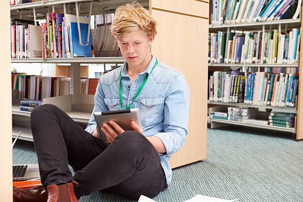 istock Male College Student Studying In Library With Digital Tablet 510613601