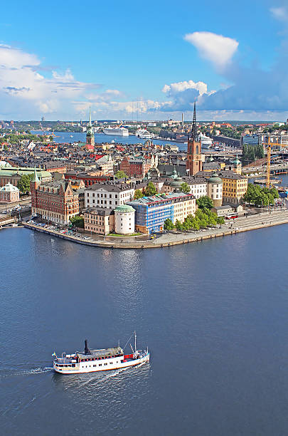 alte stadt panorama von stockholm, schweden und boot - stadsholmen stock-fotos und bilder