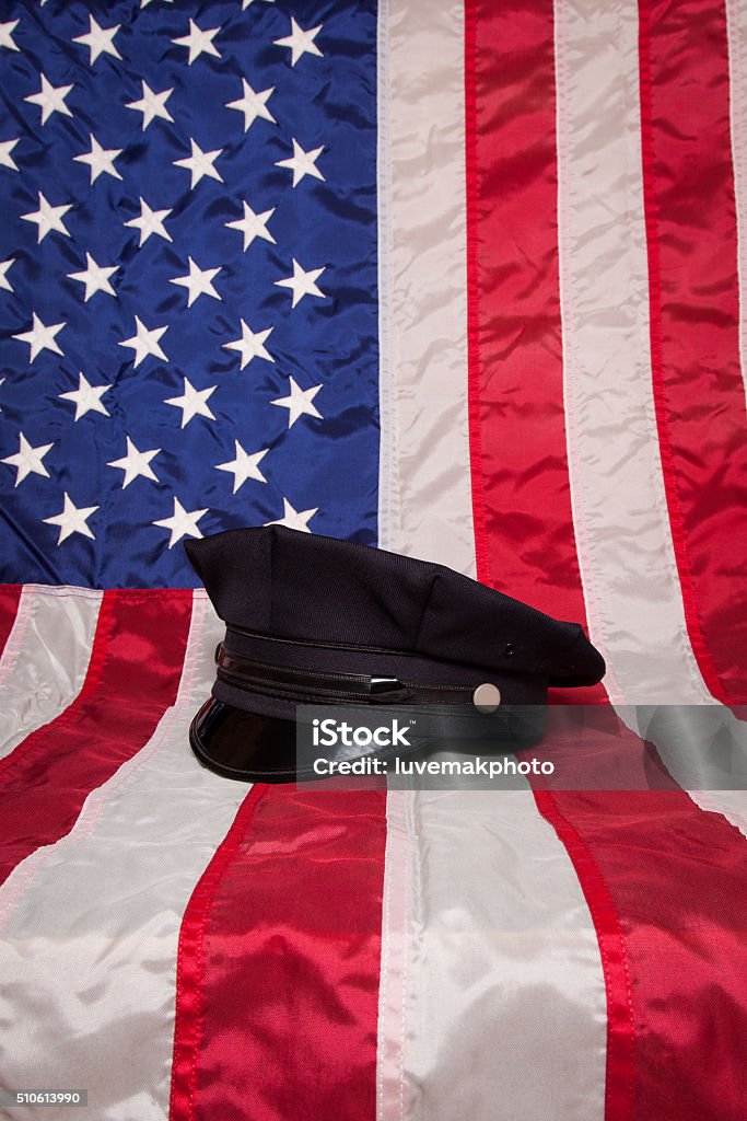 Police Gear A police hat on an American flag background. Backgrounds Stock Photo