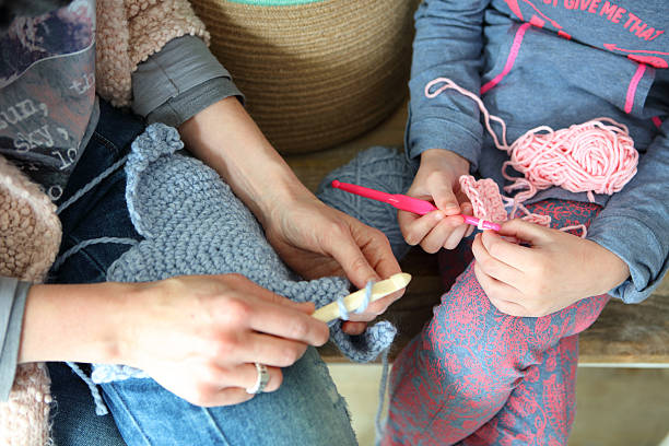 Mother Teaching Her Daughter To Crochet stock photo
