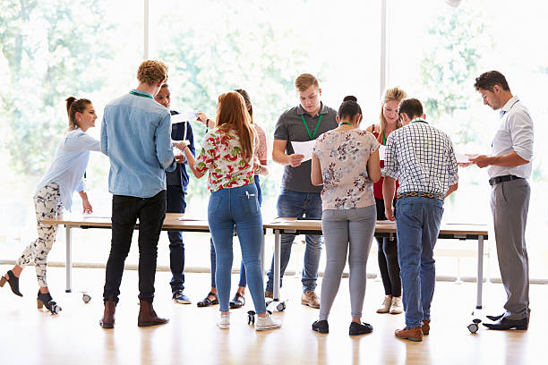 istock Teacher With College Students Standing By Desks In Classroom 510615407