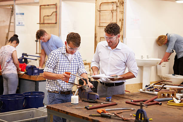 istock Teacher Helping College Students Studying Plumbing 510616975