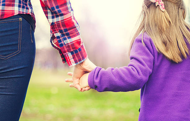istock Child walking and holding hands with her parent 510618140