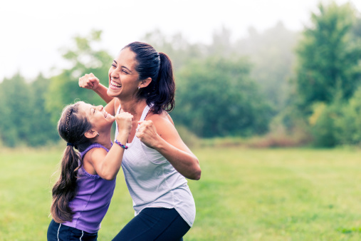 Mother and daughter doing exercises outdoors