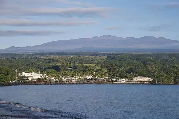 The morning sun and clear skies reveal the telescope clustered peak of Mauna Kea above the historic downtown of Hilo, Hawaii.