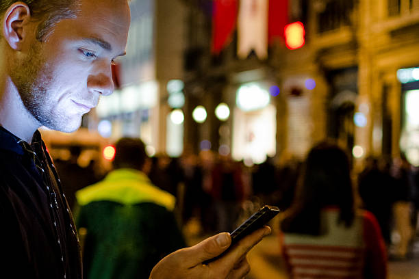 istock Young man typing text message at city street 510624550
