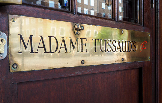 London, Uk - JUNE 12TH, 2015 - Detail of entrance of Madame Tussaud's museum with brass ensign and wooden door.