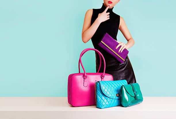Woman thinking with many colorful bags. Shopping. Fashion image. Isolated on light blue. All bags are our original products. purse stock pictures, royalty-free photos & images