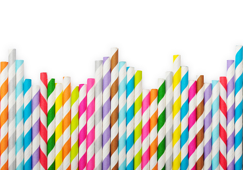 Striped drink straws of different colors in row isolated on white background