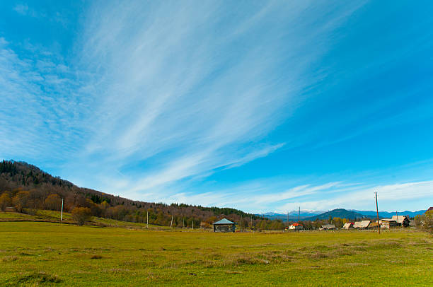Zielonej łące i niebieski Błyszczący Krajobraz z chmurami – zdjęcie