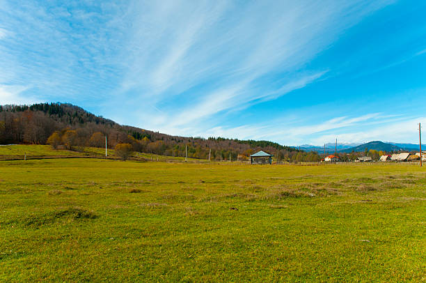 緑の牧草地、村の家 バクリアニ ストックフォト