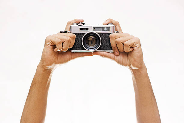 manos sosteniendo un wintage cámara aislado sobre blanco - competición fotos fotografías e imágenes de stock