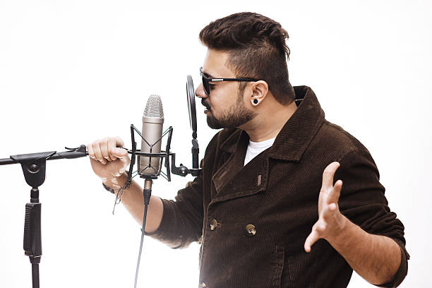 Men brown coat and glasses singing into a condenser microphone stock photo