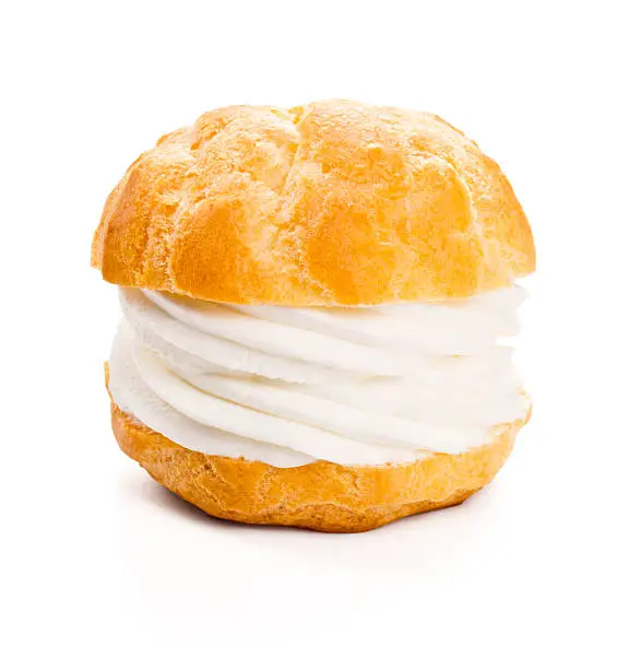 A profiterole or cream puff isolated on white. Profiteroles are a French dessert made from choux pastry that is baked, cut in half and filled with pastry cream, whipped cream or soft serve ice cream.