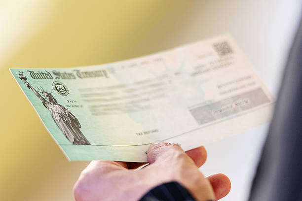 Tax refund Men hands holding a US Government Treasury check refund stock pictures, royalty-free photos & images