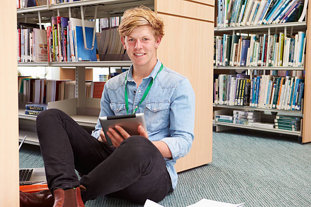 istock Male College Student Studying In Library With Digital Tablet 510633135