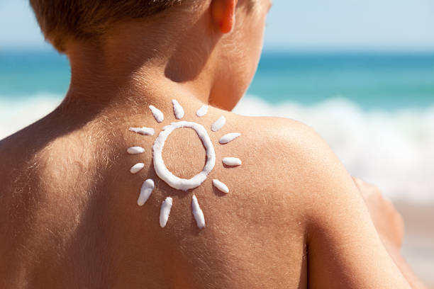 crema solare in spiaggia - cute kid foto e immagini stock