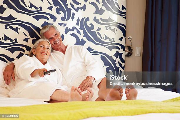 Senior Couple Relaxing In Hotel Room Watching Television Stock Photo - Download Image Now