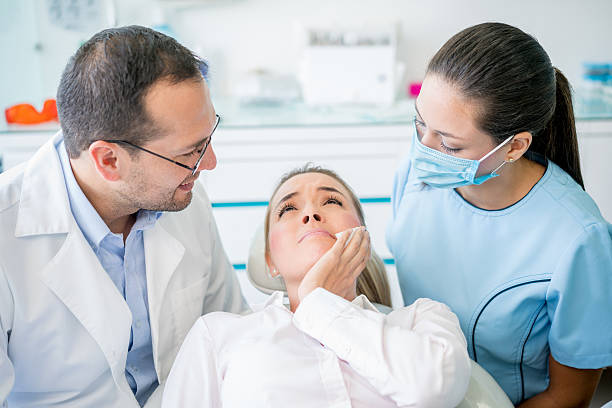 Woman with a tooth pain at the dentist Young woman with a tooth pain at the dentist - dental care concepts abscess stock pictures, royalty-free photos & images