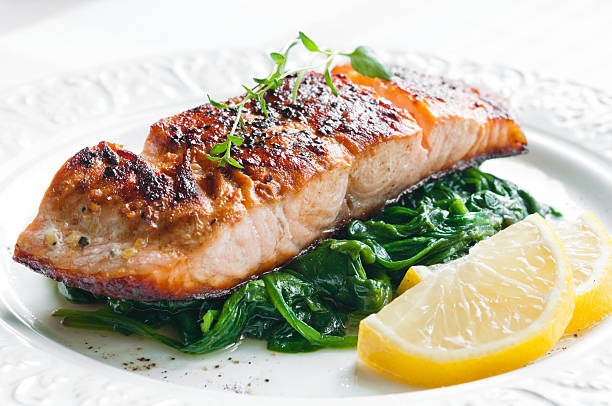 salmão com espinafre - prepared fish fish grilled close up imagens e fotografias de stock