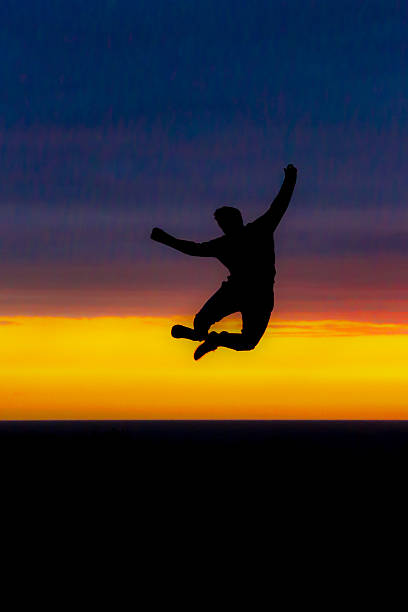 istock Man jumping in the air silhouetted by the sunset 510639171