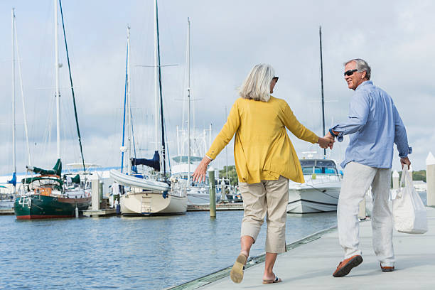 istock Happy senior couple walking along harbor holding hands 510640240