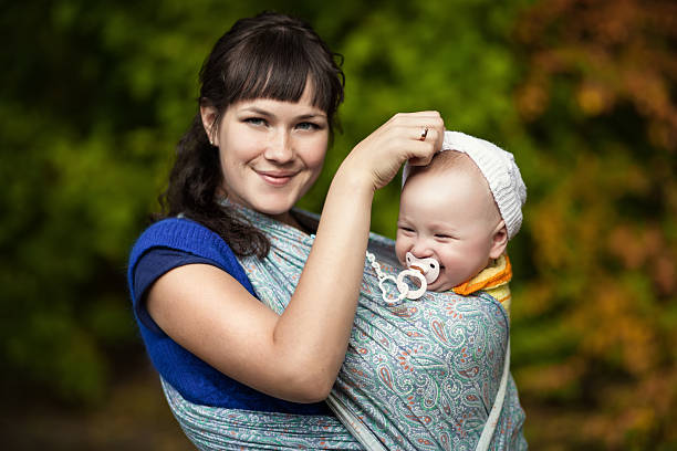 mother with her baby in a sling summer