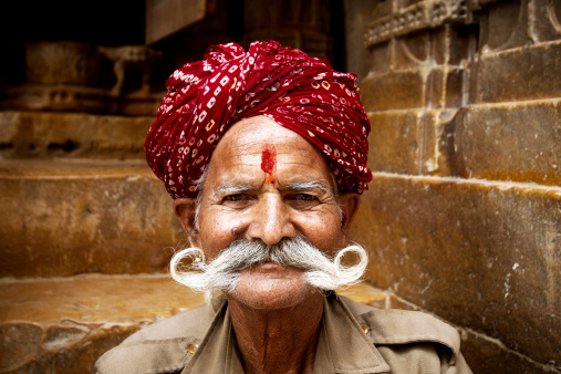 Portrait of senior Indian man sitting at the gate of Jain Temple at Jaisalmer, Rajasthan.