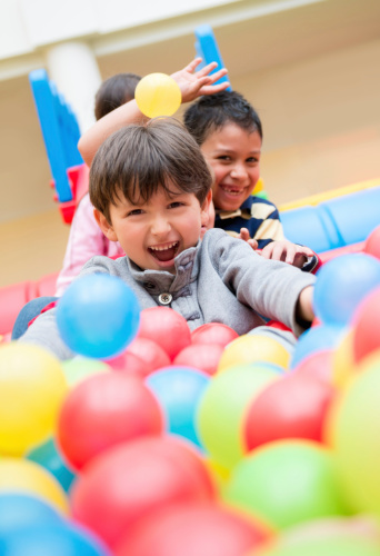 Kids playing at a ball pool and looking very happy