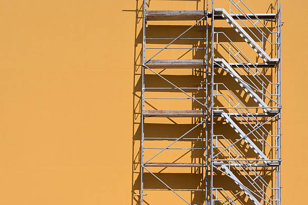 Steps of a scaffold Scaffold beside an ocher colored building.  scaffolding stock pictures, royalty-free photos & images
