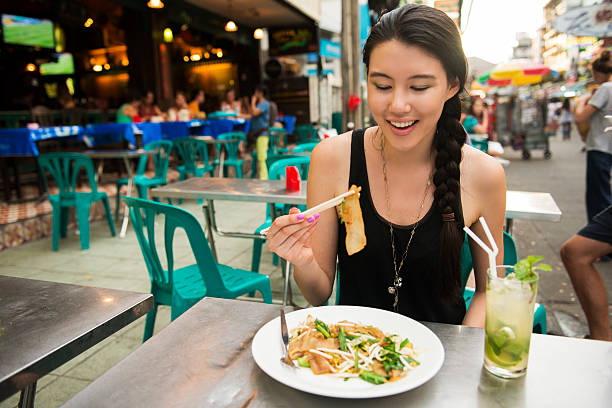 comiendo comida tailandesa en calle khao san bangkok tailandia - khao san road fotografías e imágenes de stock