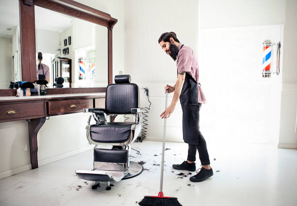 Male barber sweeping floor Male barber sweeping floor sweeping photos stock pictures, royalty-free photos & images