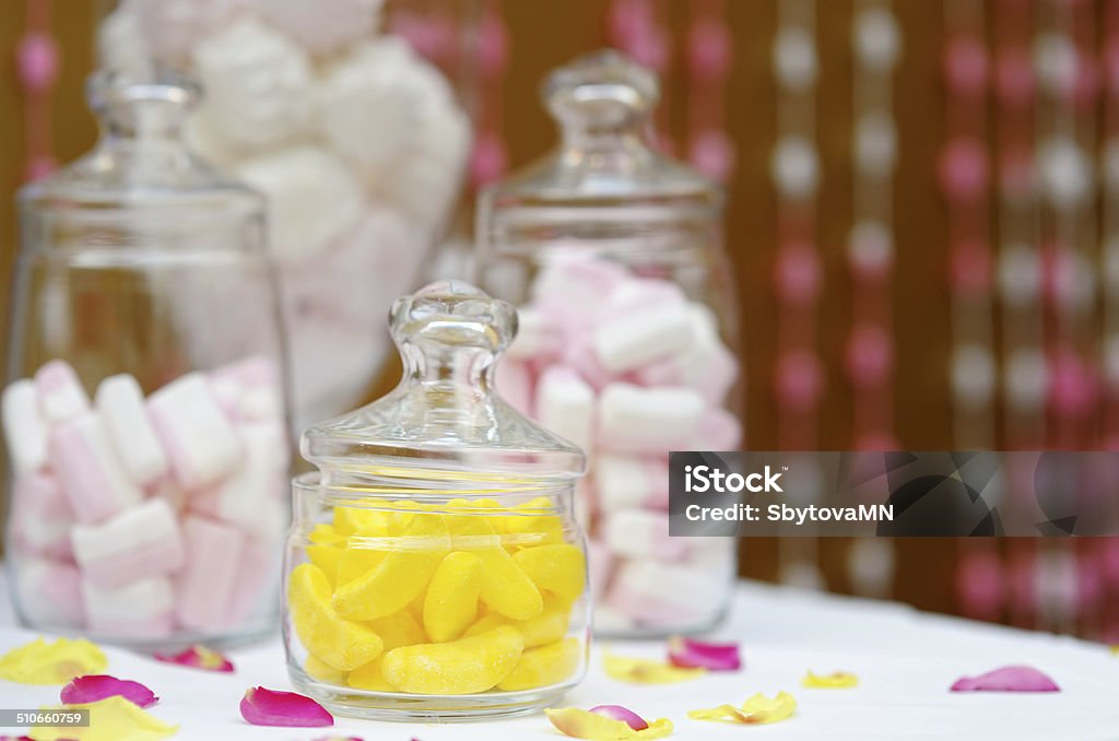 Sweet table or candy bar Yellow fruit candy and marshmallow in glass jars on sweet table or candy bar Baked Stock Photo