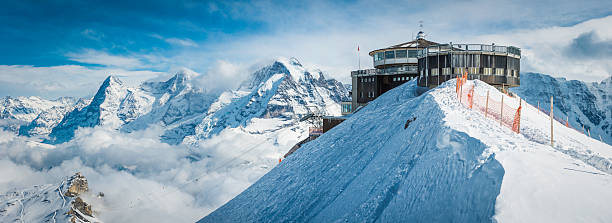 straßenbahn-haltestelle auf schneebedeckte berge und idyllische winter peak panorama - swiss culture european alps eiger mountain range stock-fotos und bilder