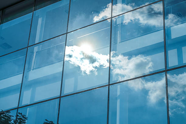 istock Sun ray and blue sky reflection on window office building 510675134