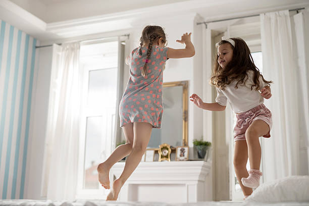 istock Girls having fun in bedroom while jumping on a bed. 510679478