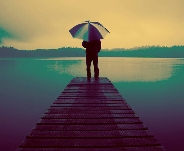 istock Man Holding Umbrella Jetty Tranquil Lake Concept 510679488