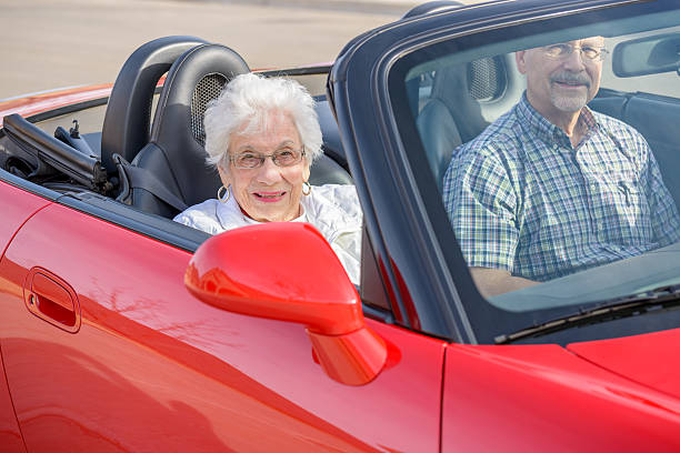 älterer mann bringt witwe mutter für fahrt in rot mit fixierbaren ärmeln - road trip collectors car sports car convertible stock-fotos und bilder