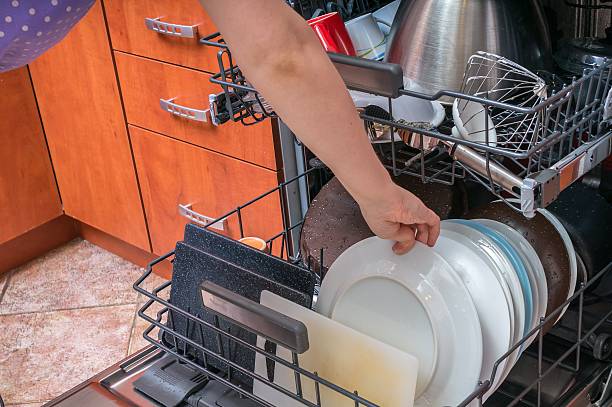 istock Woman puts dirty dish into dishwasher machine. 510683462