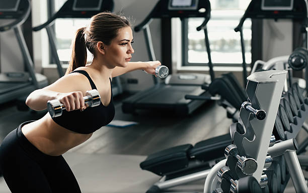 istock Young woman doing exercise with dumbbell in gym 510684686