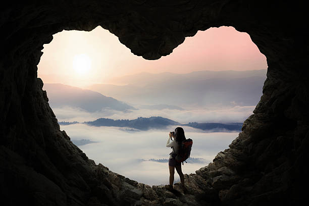 istock Female hiker taking photo in cave 510688430
