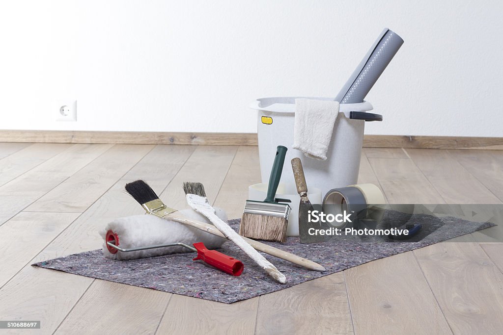Paint apartment Paint apartment with paint, brush, paint roller, bucket, adhesive tape on felt and parquet. Painting - Activity Stock Photo