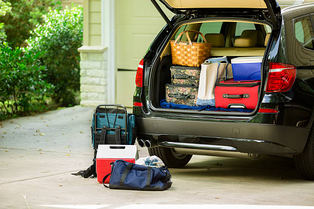 Family vehicle packed, ready for road trip, vacation outside home. Family sport utility vehicle packed up and ready to go on summer road trip or vacation. Outside house.  full stock pictures, royalty-free photos & images