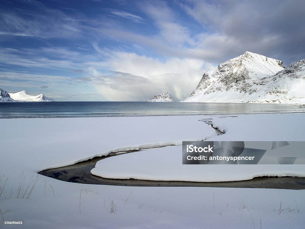 Frozen snow covered beach, Lofoten Islands Arctic Norway The beach at Haukland nr Leknes in the Lofoten Islands covered in snow and ice in mid winter, Arctic Norway Beach Stock Photo