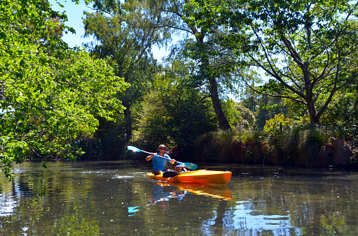 Christchurch, New Zealand - December 4, 2015: Father and child kayak on the Avon River Christchurch. Much of the land along the Avon River downstream from the central city was damaged in the 2010 Canterbury earthquake