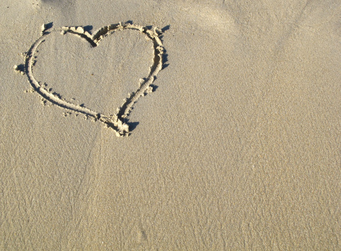 heart shape in the sand,space on the right for copy.