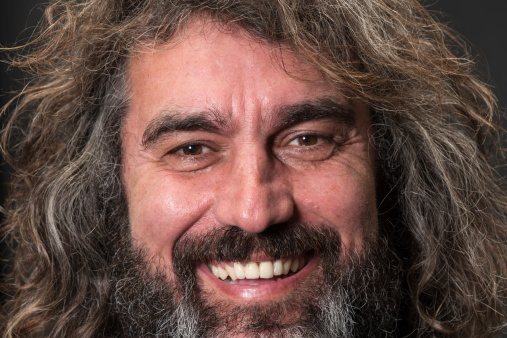 Portrait of a fifty something smiling man on gray background.