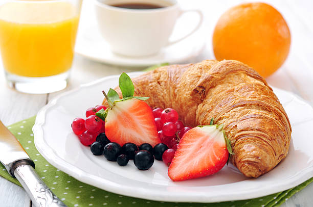 Fresh croissant with berries Fresh croissant with berries, coffee and orange juice closeup continental breakfast photos stock pictures, royalty-free photos & images