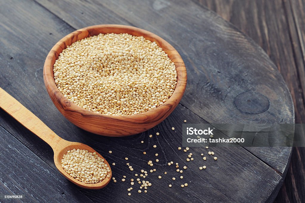 Raw quinoa seeds Raw quinoa seeds in the wooden bowl on wooden background closeup Backgrounds Stock Photo