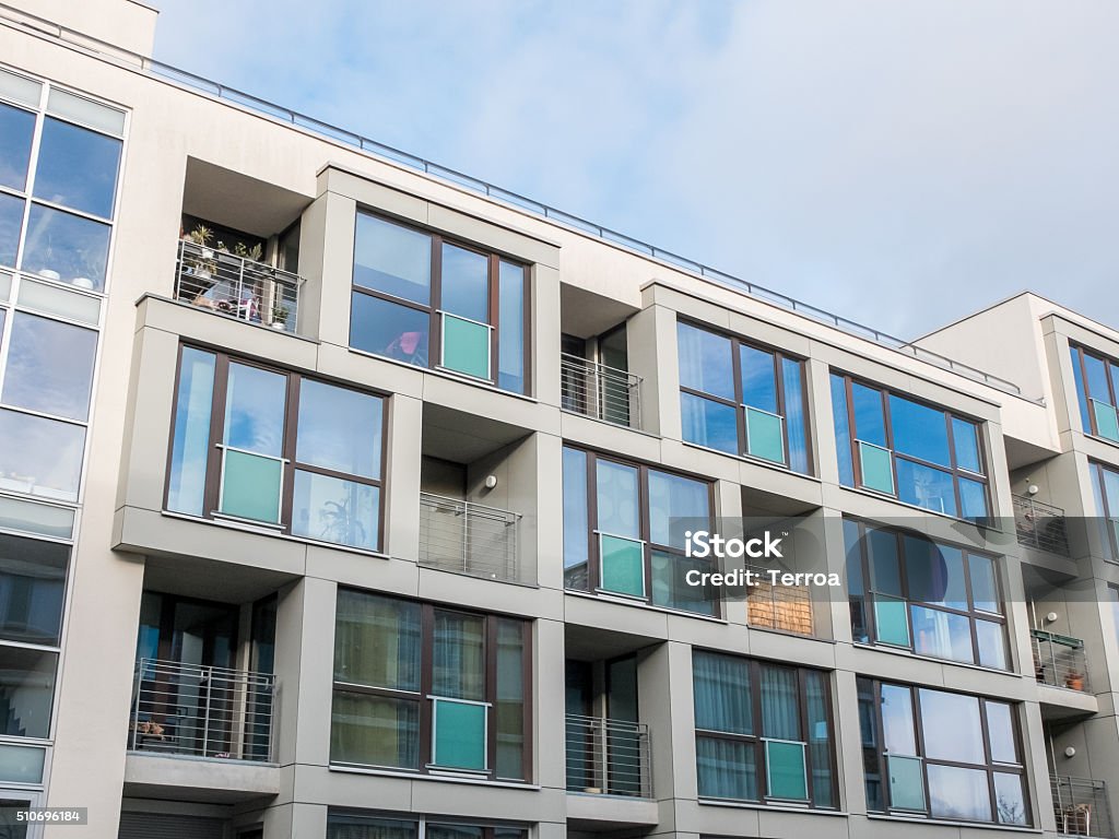 Low Rise Apartment Building with Balconies Low Angle Exterior View of Contemporary Low Rise Apartment Building with Small Balconies and Large Windows with Cloudy Blue Sky in Background Apartment Stock Photo